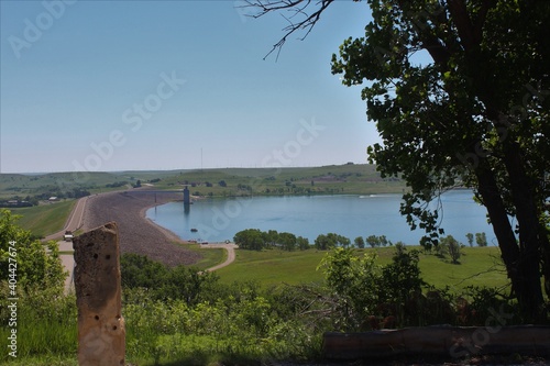 Wilson Lake reservoir with blue water, tree's, a dam and a field with grass south of Lucas Kansas USA.