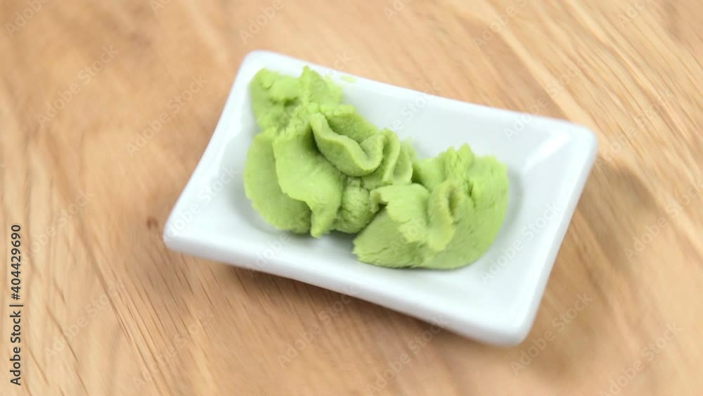 close-up of wasabi spinning on a wooden table. japanese seasoning for sushi and sashimi close-up of wasabi spinning on a wooden table. japanese seasoning for sushi and sashimi