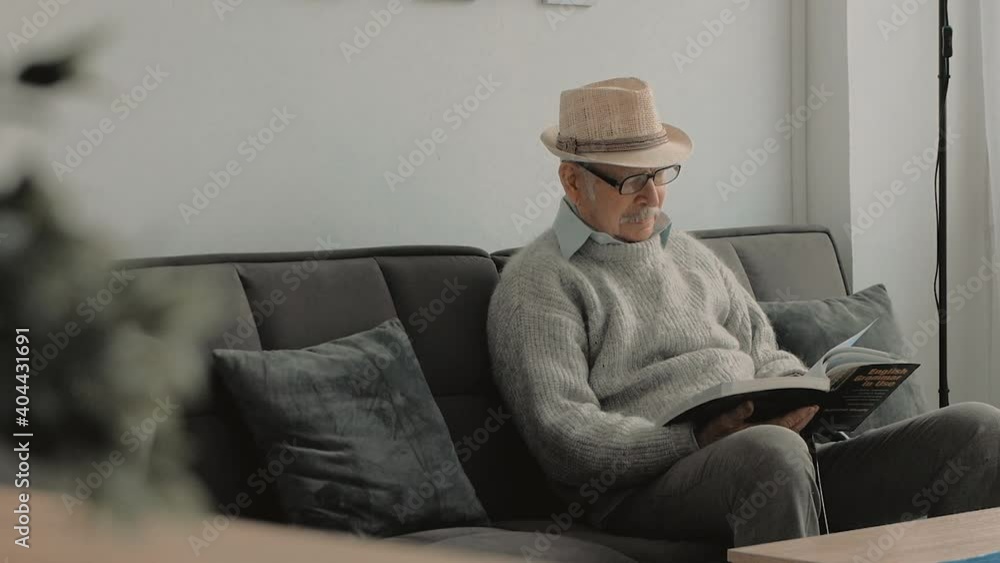Elderly man reading a book. Old man with gray mustache, hat, glasses. Elderly man reading a book. Old man with gray mustache, hat, glasses.