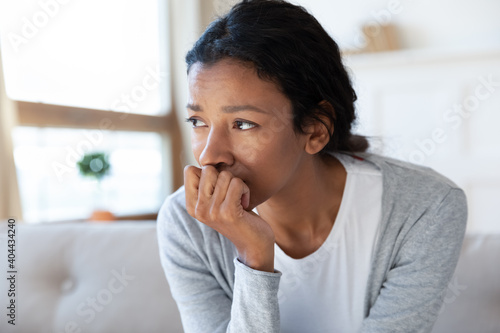 Quadro em tela Close up head shot frustrated unhappy young african mixed race woman lost in thoughts, feeling desperate alone at home