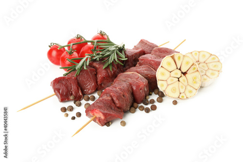 Skewers with raw meat and vegetables isolated on white background