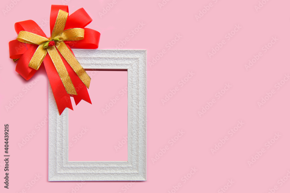 Picture frame mockup and  ribbon on a pink  background with copy space..