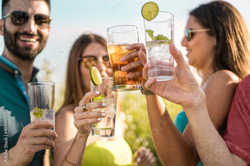 Foto Group of young people clinking cocktail glasses outdoors in the summer