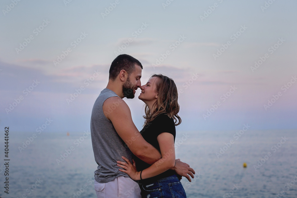 Happy young couple in love, hugging and kissing on the beach