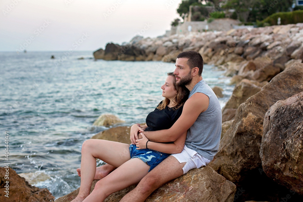 Happy young couple in love, hugging and kissing on the beach