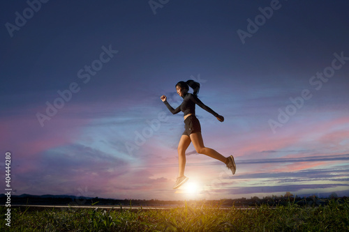 A beautiful sporty woman runing on the shore of a lake in sports.Sporty young woman running on road in beautiful nature.