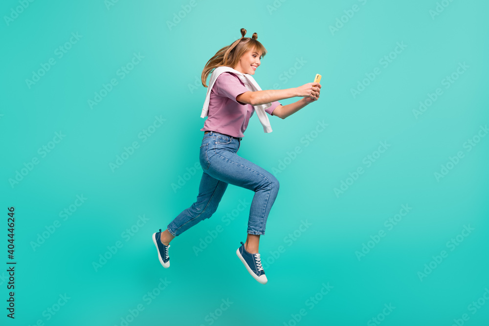 Full size profile side photo of young smiling girl with jumper on shoulders blogger jump isolated on turquoise color background