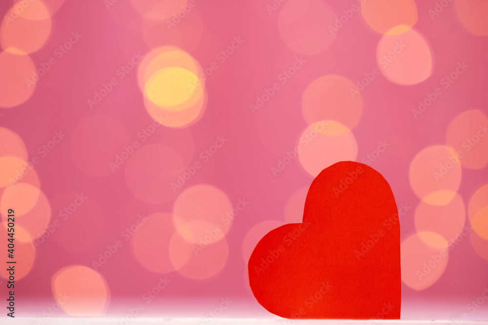 Red heart decoration against pink bokeh background