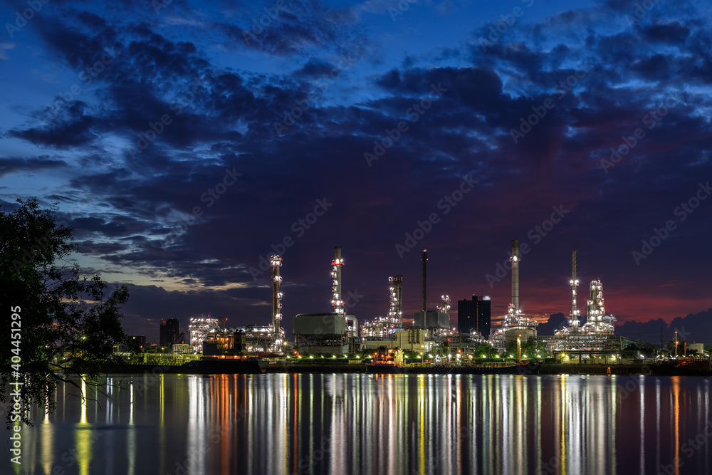 Oil and gas refinery plant factory with refection on river at twilight. petrochemical and energy industry concept.