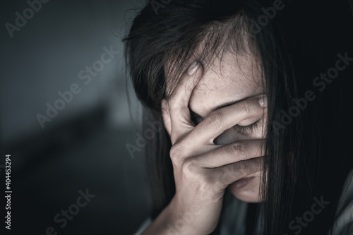Scared young woman sitting in the corner of her bedroom, despair rape victim waiting for help,The concept of stopping violence against women and rape.