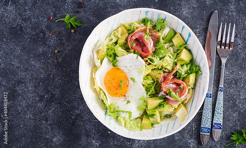 Ketogenic, paleo diet. Fried egg, prosciutto, avocado and fresh salad. Keto breakfast. Brunch. Top view, overhead, flat lay