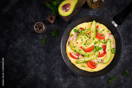 Keto breakfast. Omelette with ham, tomatoes and avocado on grey table. Italian frittata. Keto, ketogenic lunch. Top view, overhead, copy space