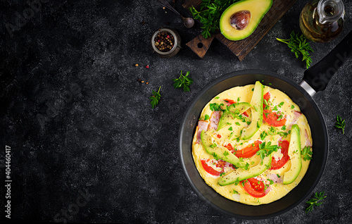 Keto breakfast. Omelette with ham, tomatoes and avocado on grey table. Italian frittata. Keto, ketogenic lunch. Top view, overhead, copy space