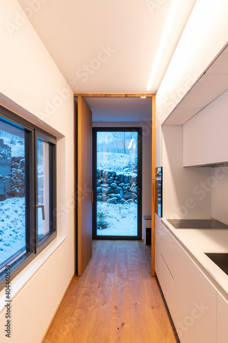 White modern kitchen with windows of view of nature and snow