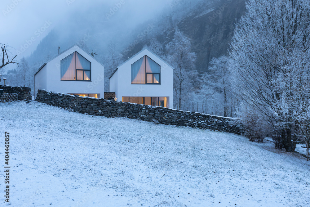 Modern white house with large windows surronded by nature, snow and fog Modern white house with large windows surronded by nature, snow and fog