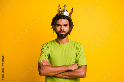 Photo of confident handsome young man crossed hands wear crown rich royalty king isolated over yellow color background © deagreez