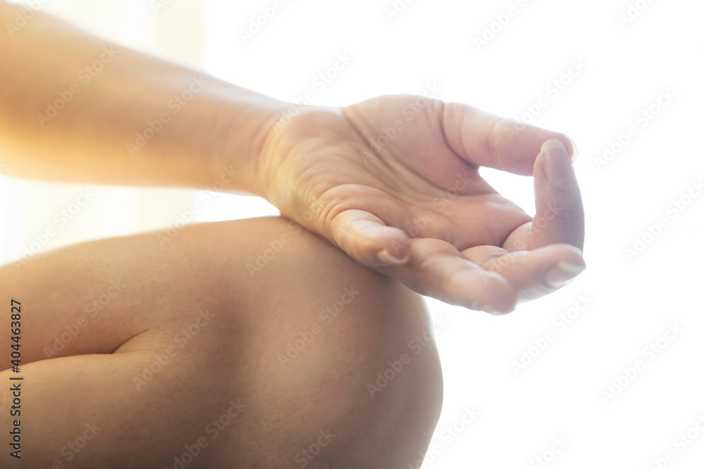 Closeup of woman's hands meditating indoors. Gentle meditative concept. Lotus position (Padmásana) Closeup of woman's hands meditating indoors. Gentle meditative concept. Lotus position (Padmásana)