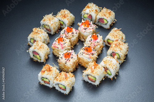 Asian cuisine. Sushi with avocado and red fish on a dark background.