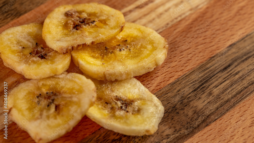 Dried banana slices on a wooden board