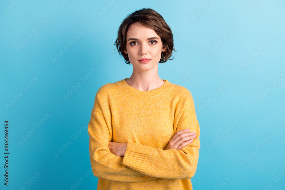 Obraz premium Photo portrait of calm serious female student with crossed hands wearing yellow jumper isolated on vivid blue color background