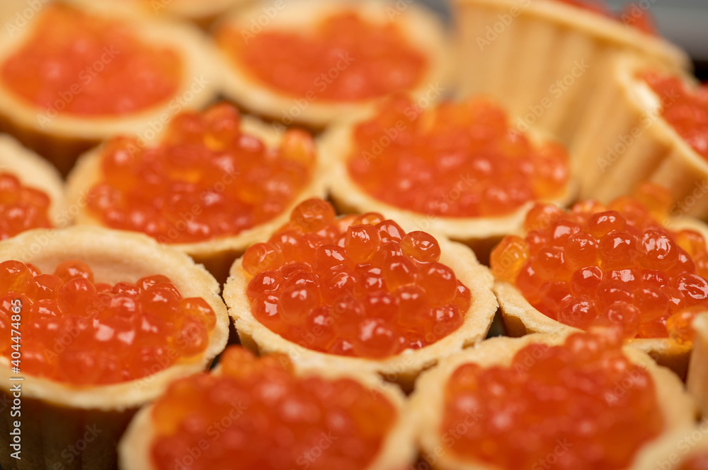 Tartlets with salmon caviar on a platter. Close-up, selective focus. Tartlets with salmon caviar on a platter. Close-up, selective focus.