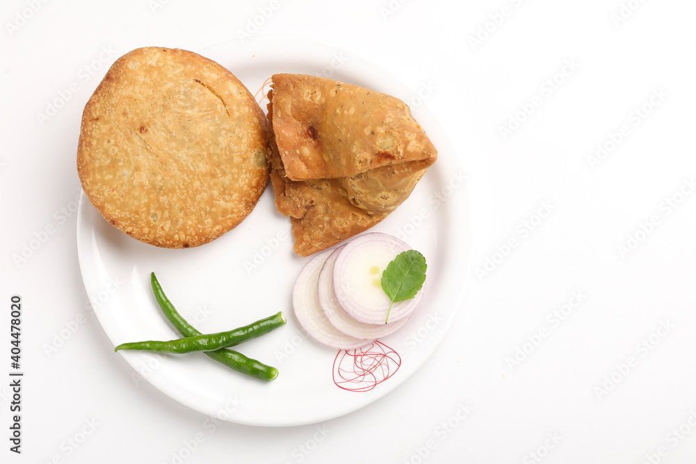 Kachori and potato samosa with green chilly in plate. famous spicy snack in india Kachori and potato samosa with green chilly in plate. famous spicy snack in india