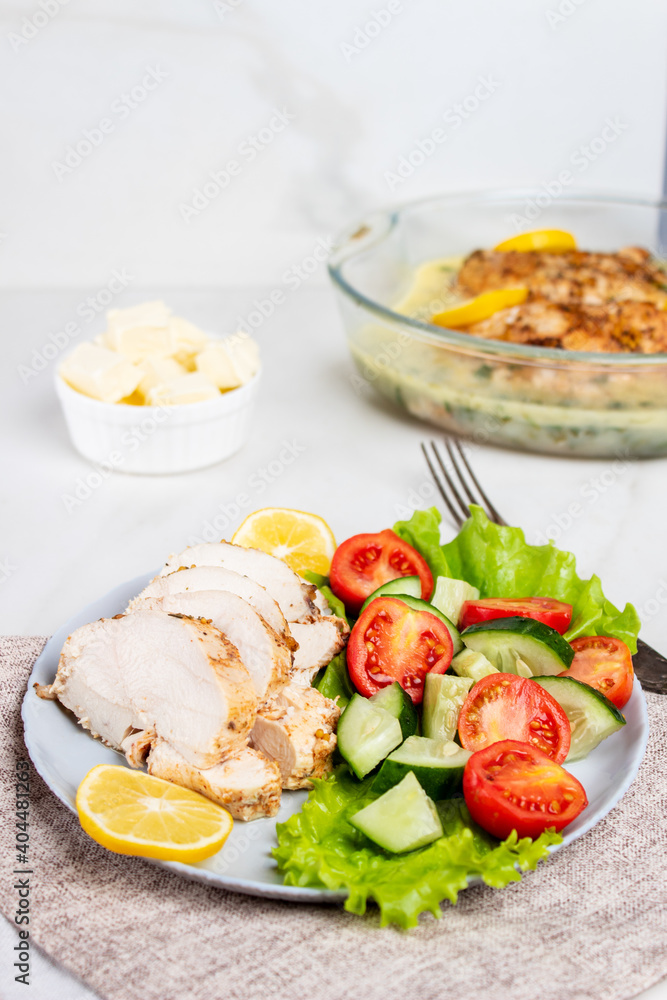 Chicken breasts with lemon sauce. Sliced chicken and fresh vegetable salad. Chicken breasts with lemon sauce. Sliced chicken and fresh vegetable salad.