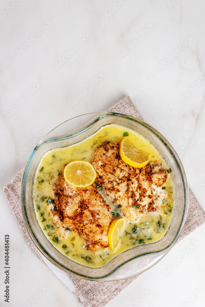 Chicken breasts with lemon sauce in baking dish, closeup. Top view. Chicken breasts with lemon sauce in baking dish, closeup. Top view.