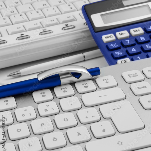 Workplace with calculator and PC two keyboards close up photo