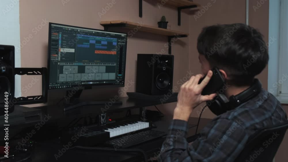 The musician works on a computer and creates a musical composition. The musician works on a computer and creates a musical composition.