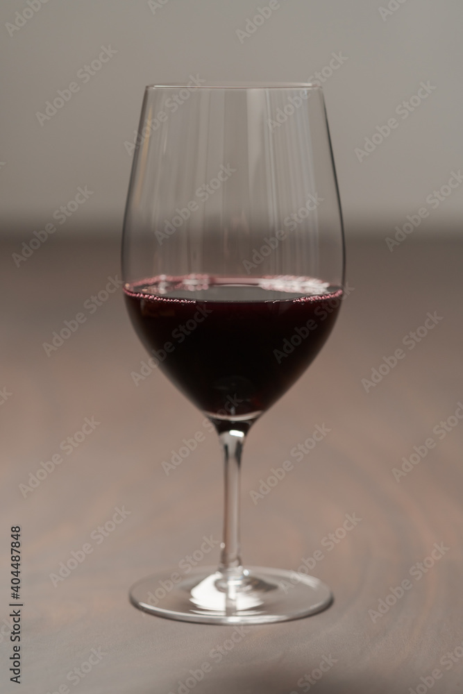 Red wine in thin wine glass on wood table