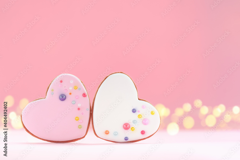 Two hearts shaped gingerbread for Valentines Day, Mother Day or Birthday on pink background.