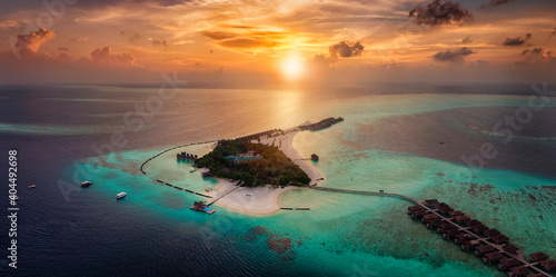 Aerial view of a beautiful paradise island in the Maldives, Indian Ocean, during a colorful sunset photo