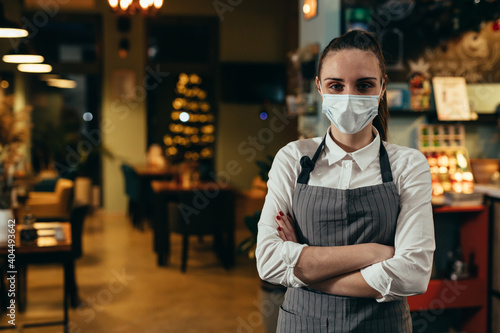 woman waitress posing in cafeteria with protective face mask