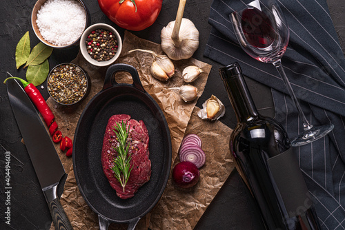 preparing filet steak with vegetable and bottle red wine with glas on wooden table