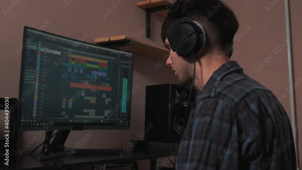 The musician works on a computer and creates a musical composition. The musician works on a computer and creates a musical composition.