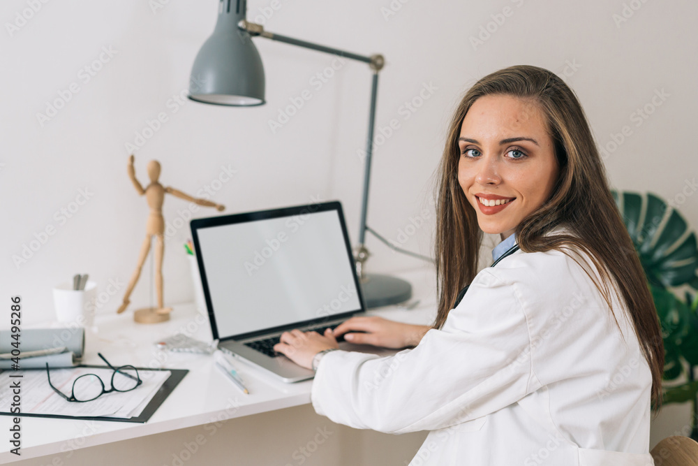 woman doctor sitting by her desk in office woman doctor sitting by her desk in office