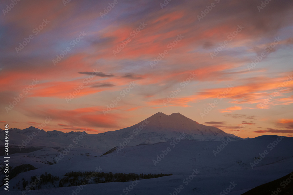 Mount Elbrus covered with snow in winter and colorful evening sky