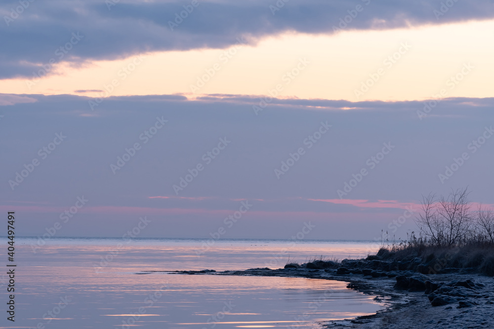 Fototapeta premium December sunrise with a beach and sea bay in the background