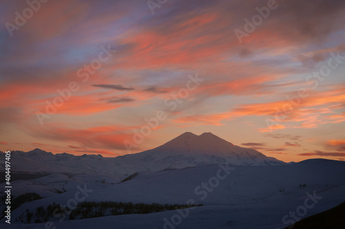Mount Elbrus covered with snow in winter and colorful evening sky