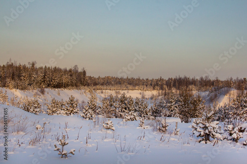Lost in Siberia. Northern landscape. Snow-covered hills and ravines, overgrown with coniferous forest and covered with snow.