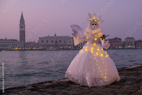 Venice, Italy - February 18, 2020: An unidentified woman in a carnival costume in front of Piazza San Marco, attends at the Carnival of Venice. © Laia