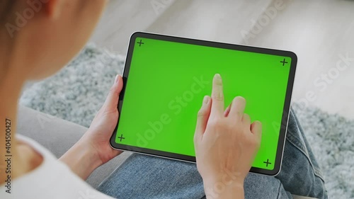 Close up of woman holding in hands a digital tablet with green screen for internet online, chromakey screen for advertising.