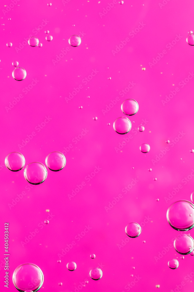 oil drops on water on a pink background