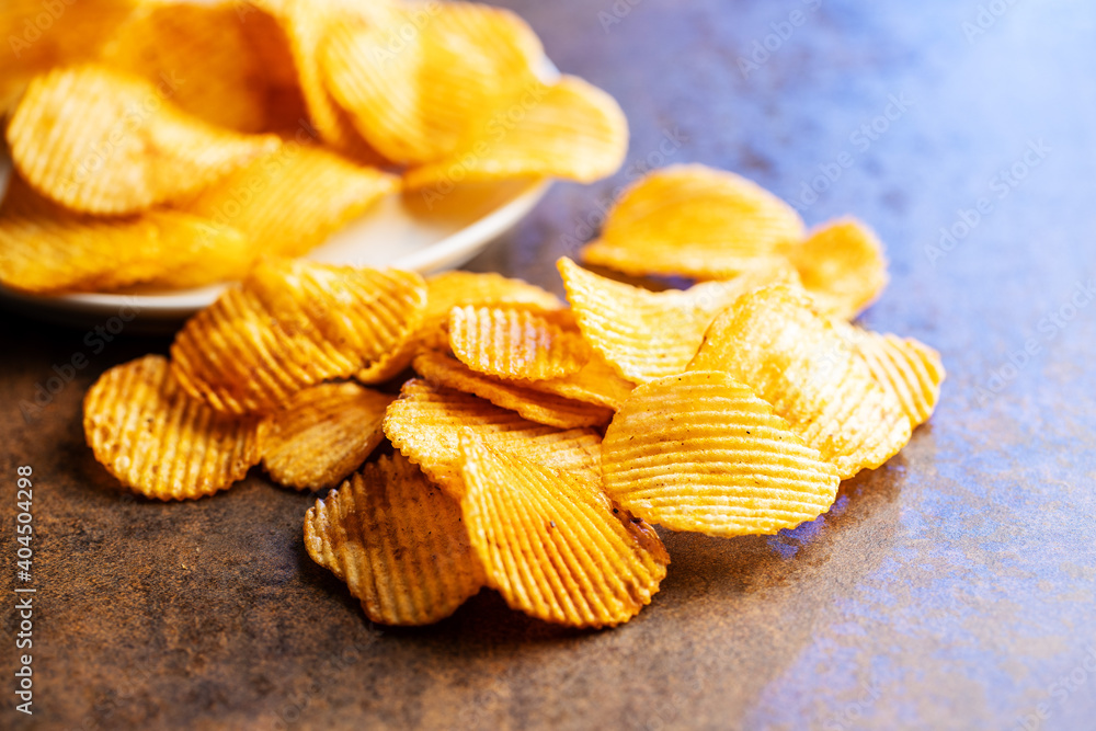 Crispy potato chips on brown table. Crispy potato chips on brown table.