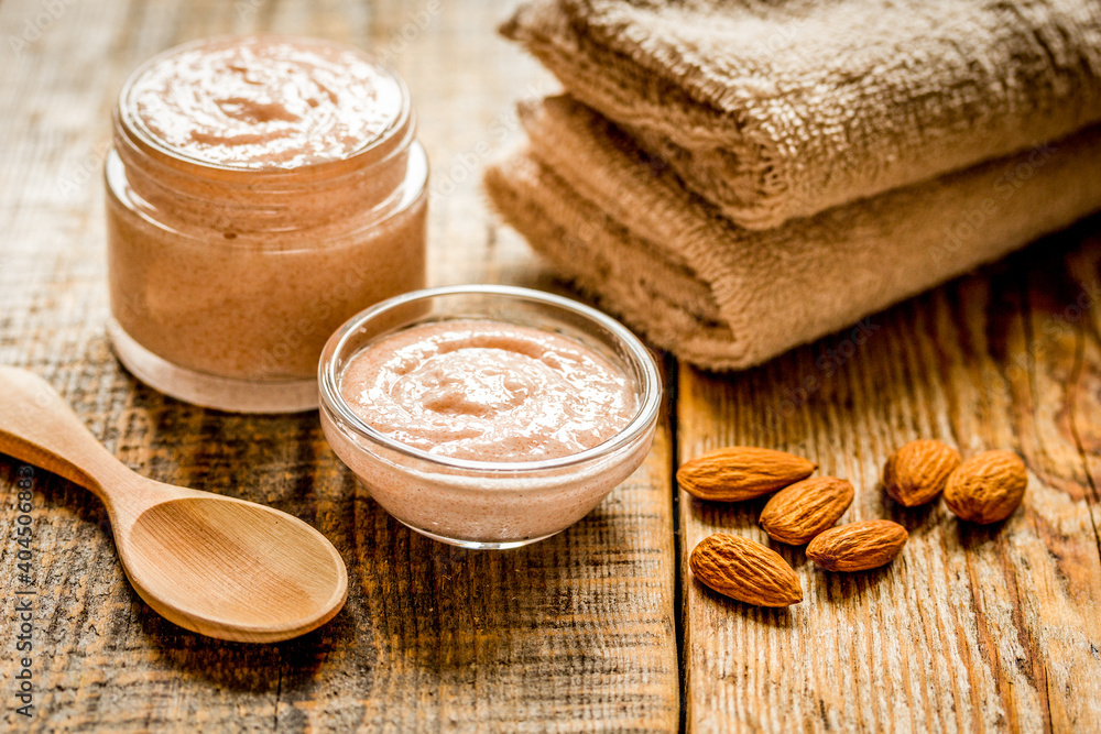 body scrub with almonds for body care on wooden table background body scrub with almonds for body care on wooden table background