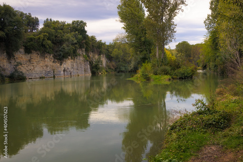 View of the river Ter as it passes through Torello, where the trees that border it are reflected in its calm waters on a summer day. Catalonia, Spain