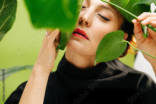 Sensual female close-up among green leaf monstera. High quality photo