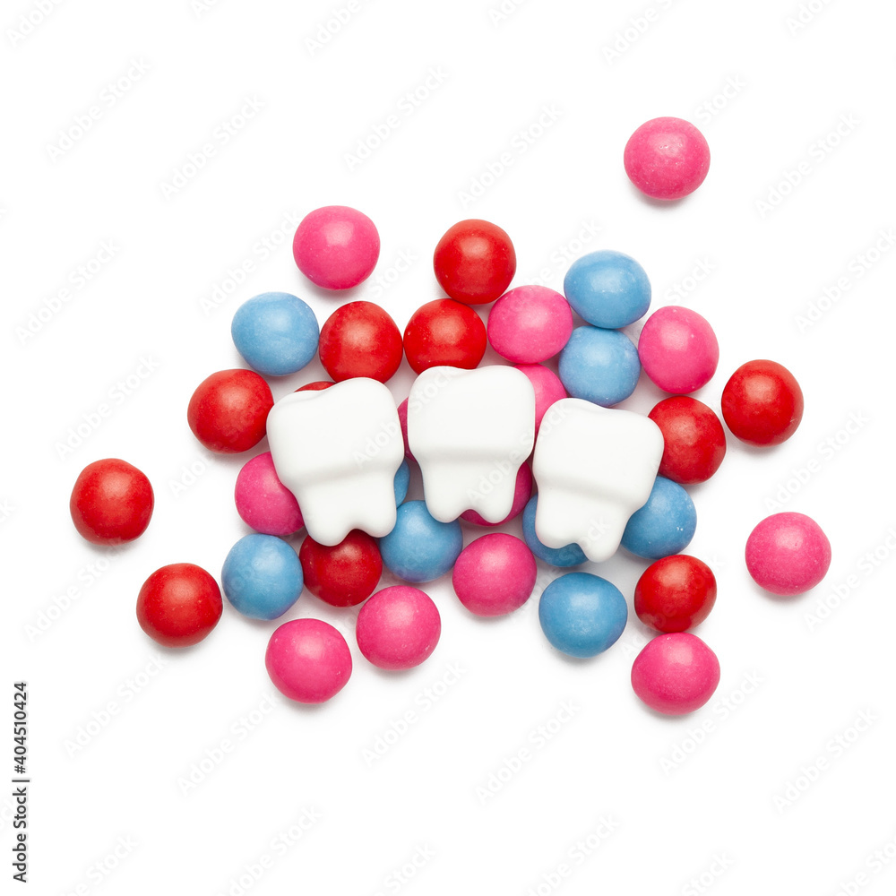 Tooths and sweet candy on a white background. Harmful sugary foods for teeth. Tooths and sweet candy on a white background. Harmful sugary foods for teeth.