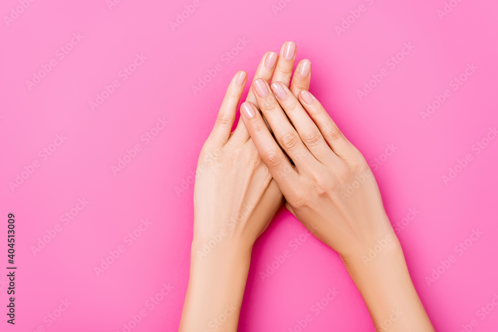 top view of groomed female hands with glossy fingernails on pink background - obrazy, fototapety, plakaty 